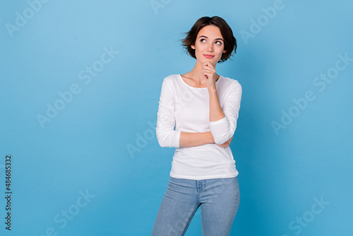 Photo of cute cheerful smart intelligent girl look empty space brainstorming isolated on blue color background