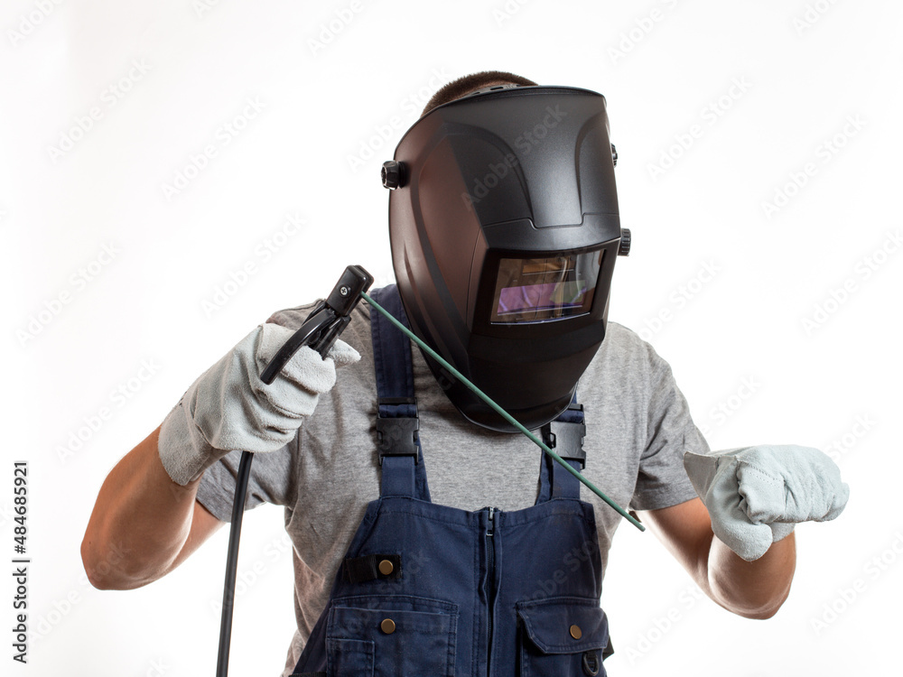 A man in a welding mask, robotic clothes and gloves, holding a wire with a welding electrode. A man in a welding mask, robotic clothes and gloves, holding a wire with a welding electrode.