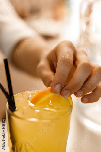 close up of a person holding a glass of orange juice