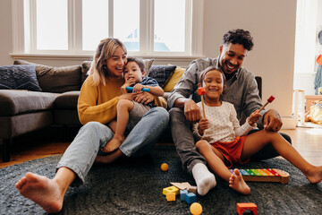 Loving parents having fun with their kids in the living room at home