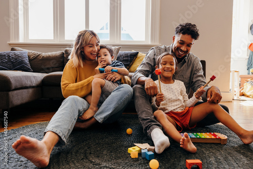 Loving parents having fun with their kids in the living room at home photo