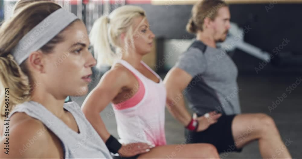 Good warmups are essential for a great workout. Group of young people during a workout. Group of diverse people stretching during workout, doing lunges together in the gym. Good warmups are essential for a great workout. Group of young people during a workout. Group of diverse people stretching during workout, doing lunges together in the gym.