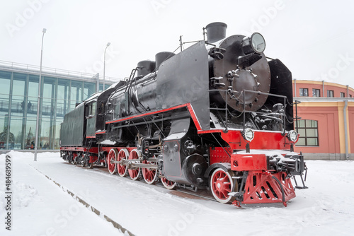 Steam locomotive of black color on the railway road in winter.