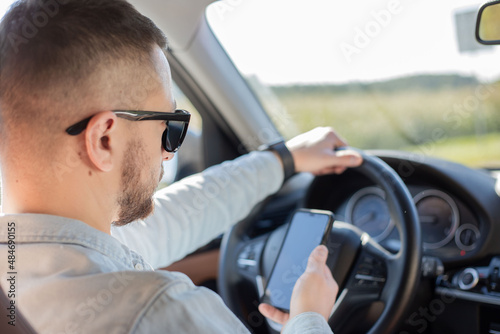  handsome man using mobile phone while driving.