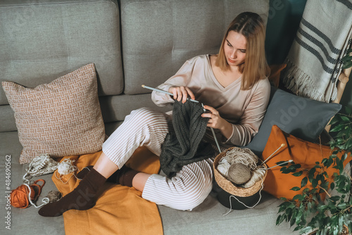 Knitting.Girl knitting at home.Handmade zero waste,upcycling,New small business employment opportunity concept.Hobby knitting and needlework for mental health.Knitted background,eco friendly knitting photo