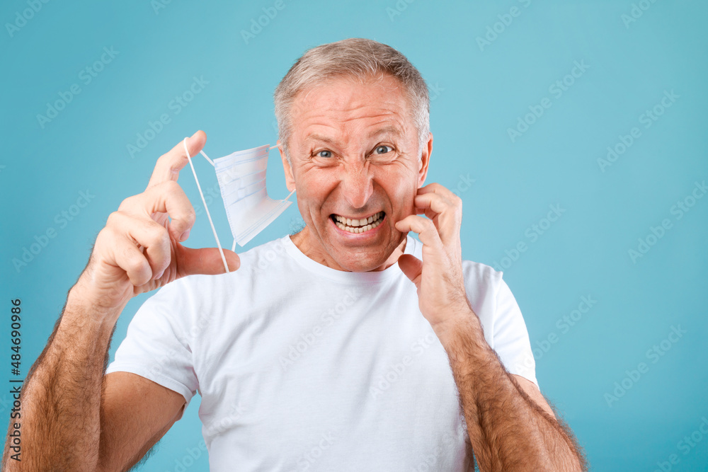 Displeased Mature Man Scratching Skin After Wearing Protective Medical Mask Displeased Mature Man Scratching Skin After Wearing Protective Medical Mask