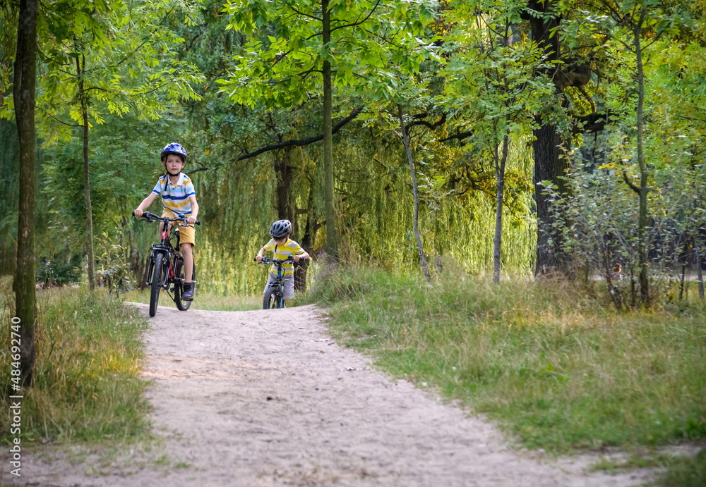 Two little boys children having fun on Balance Bike on a country road. Two little boys children having fun on Balance Bike on a country road.