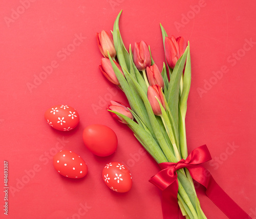 Easter decoration. Overhead view of red paint egg and fresh tulip bouquet. Christian Spring Holiday