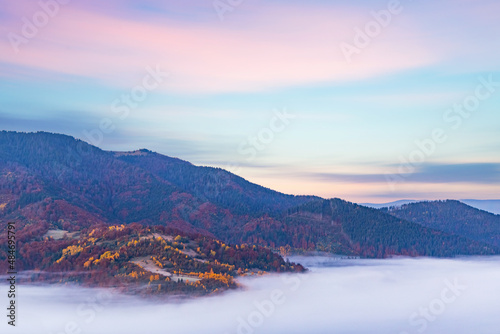 Hill with trees against gorge covered with fog in autumn © YouraPechkin