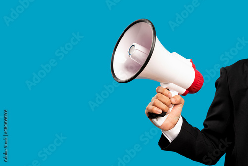 Announcement concept. Hand holds megaphone. Isolated on blue background.