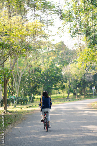 asian woman biking bicycle at park