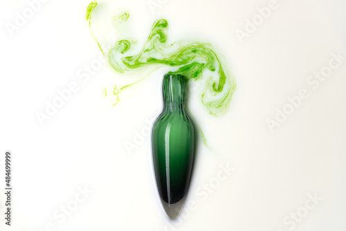 Potion in green glass flask bottle on white background. Magic wizardry elixir liquid . Witchery ingredient for healing and spell.
