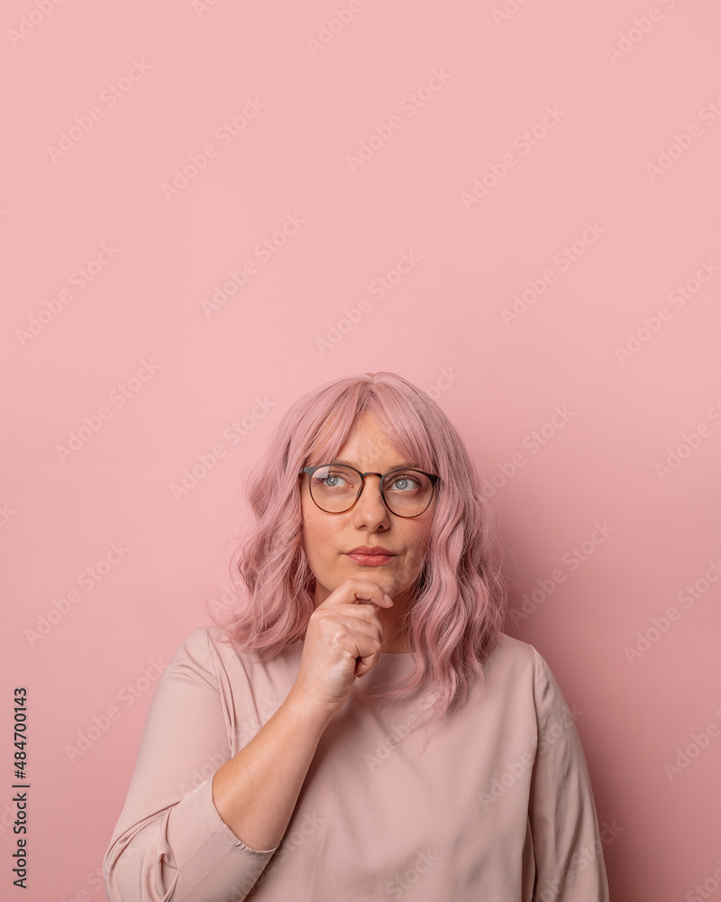 Portrait of attractive focused concentrated woman, thinking, dreaming against pink background. Portrait of attractive focused concentrated woman, thinking, dreaming against pink background.