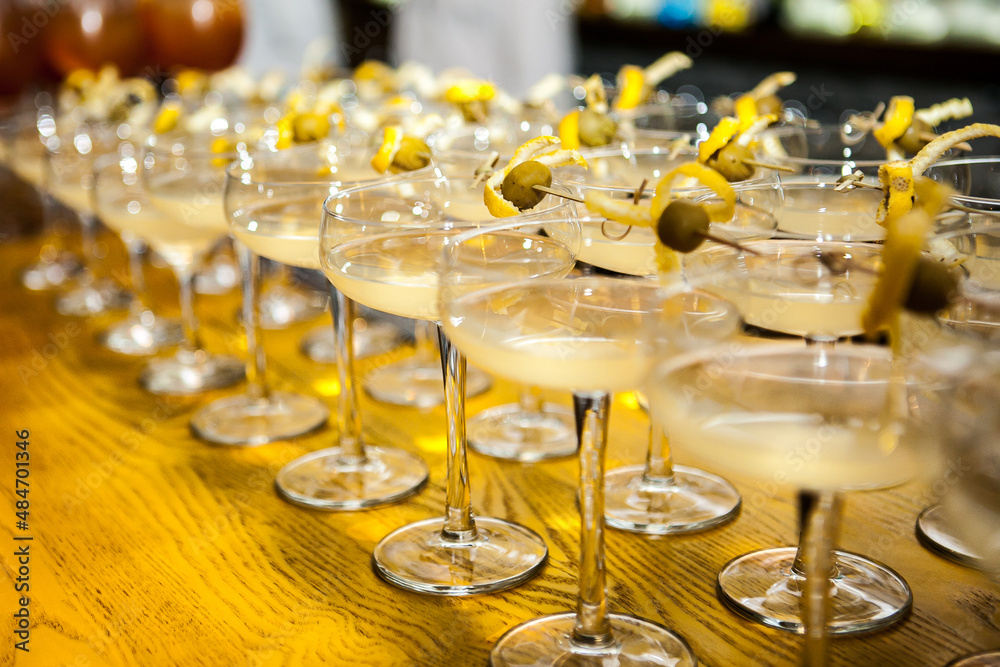 a large number of cocktails decorated with lemon zest