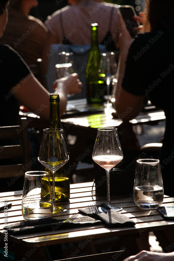 wine that is poured into glasses in the rays of the setting sun on the summer terrace