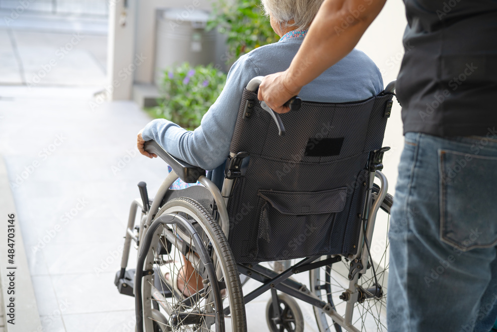Obraz premium Caregiver help and care Asian senior or elderly old lady woman patient sitting on wheelchair at nursing hospital ward, healthy strong medical concept