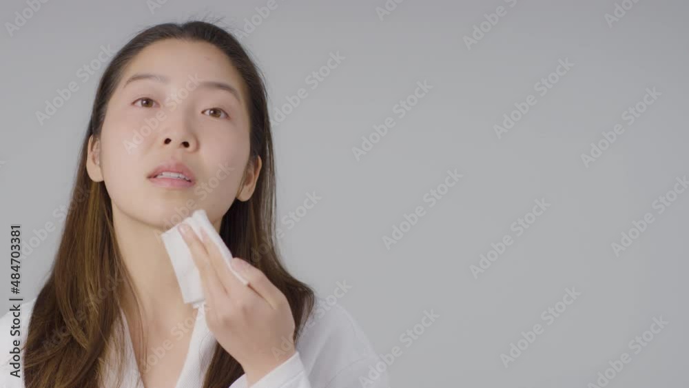 Mid Shot of Young Woman Taking off Makeup with Copy Space Mid Shot of Young Woman Taking off Makeup with Copy Space