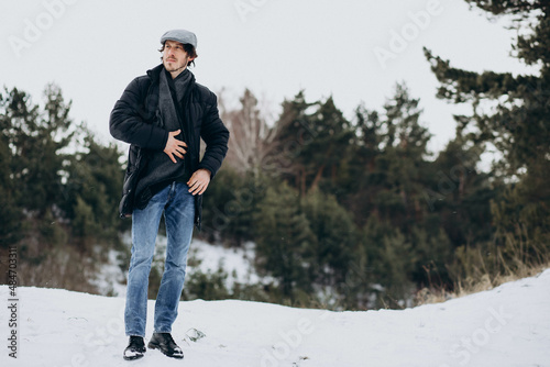 Handsome man standing in a winter park © Petro
