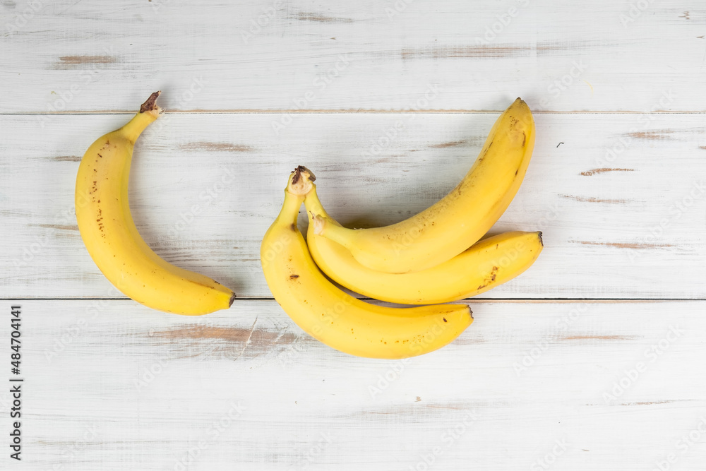 Bunch of bananas on a wooden background. Ordinary bananas with spots. Bunch of bananas on a wooden background. Ordinary bananas with spots.