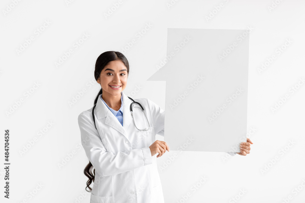 Cheerful young hindu woman doctor in white coat hold abstract space for words and thoughts with blank space Cheerful young hindu woman doctor in white coat hold abstract space for words and thoughts with blank space