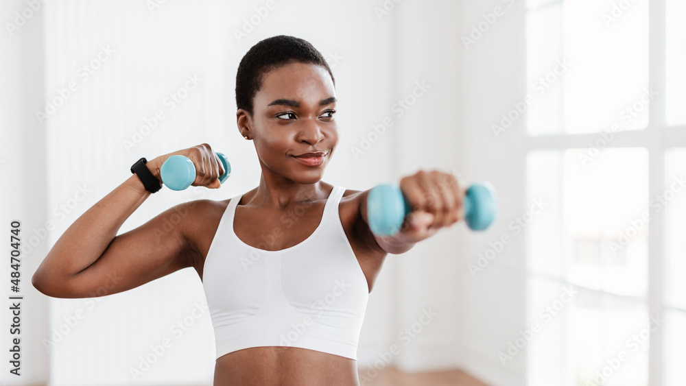 Sporty Black Lady Exercising With Two Dumbbells And Posing Sporty Black Lady Exercising With Two Dumbbells And Posing