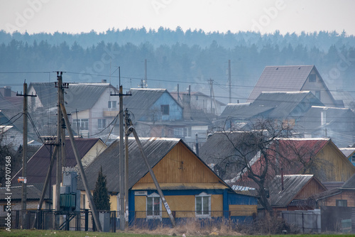 Village houses in a haze close-up against the background of the forest.