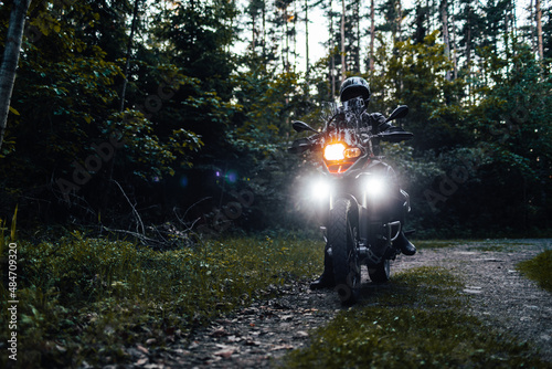 person riding a bike in the woods with lights on