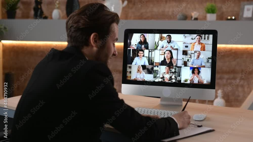 Remote group webinar, brainstorm. Successful man communicates via video conference, listening an online webinar, a course, takes notes, writes down information. Group of multiracial people on screen Remote group webinar, brainstorm. Successful man communicates via video conference, listening an online webinar, a course, takes notes, writes down information. Group of multiracial people on screen