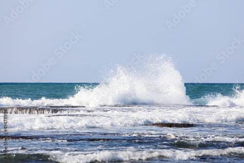 The big breaking waves during a strom at the beautiful summer sea shore background the blue sky and horizon. High quality photo photo