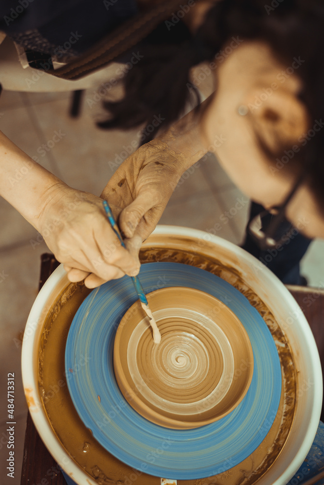 Fototapeta premium A man working on a potter's wheel. Creative work with clay.