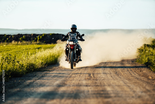 person riding a bike on a dirt road with a cloud of dust behind