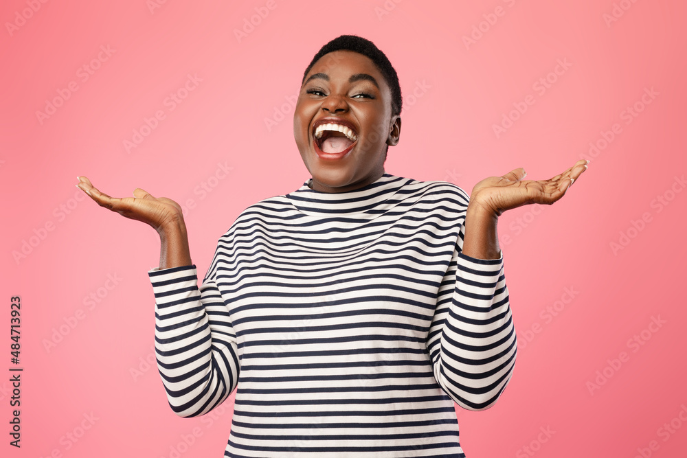 Cheerful Plus-Sized Black Lady Holding Two Invisible Objects, Pink Background Cheerful Plus-Sized Black Lady Holding Two Invisible Objects, Pink Background