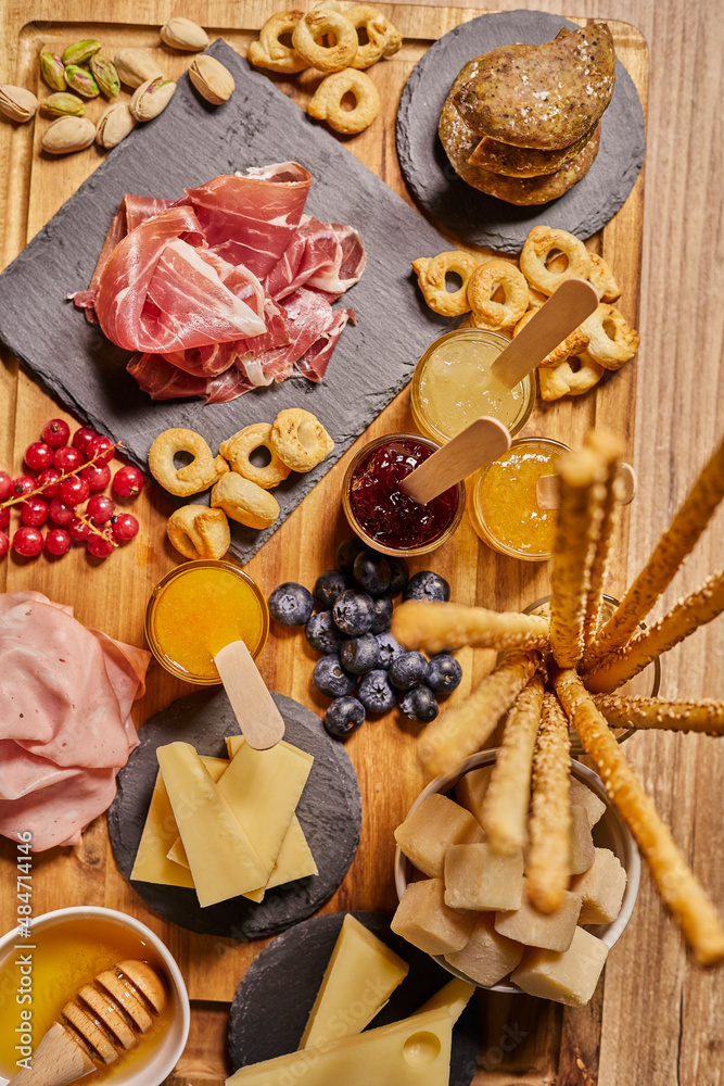 Wooden cutting board with cold cuts and cheeses Wooden cutting board with cold cuts and cheeses