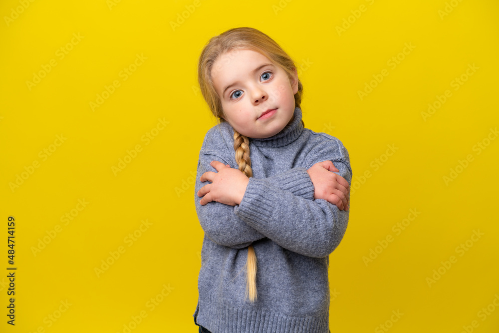 Little caucasian girl isolated on yellow background making doubts gesture while lifting the shoulders Little caucasian girl isolated on yellow background making doubts gesture while lifting the shoulders