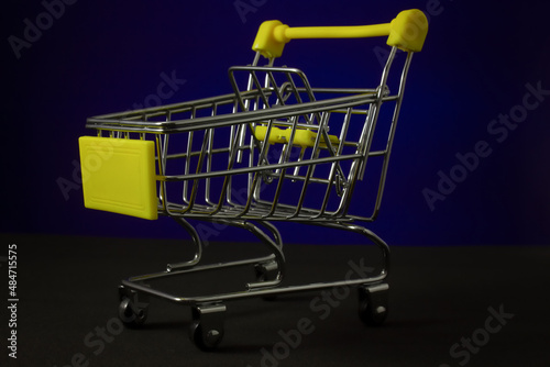 Grocery shopping cart on a dark background. Crisis concept. Online shopping, sales of goods