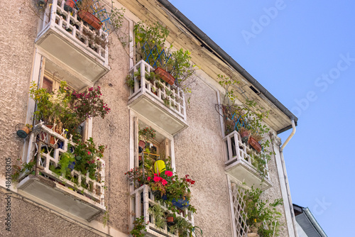 European street. French balcony. Flowers on windows and balconies. Facade of a residential building. Travel in Europe.