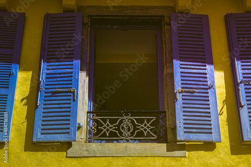 European street. Wooden shutters. Facade of a residential building. Travel in Europe. Open and closed shutters. French windows.