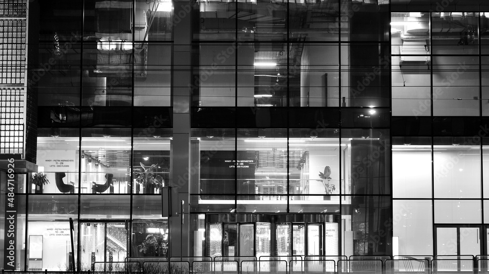 Amazing night cityscape. Office building at night, building facade with glass and lights. View with illuminated modern skyscraper. Scenic glowing windows of skyscrapers at evening. Black and white. Amazing night cityscape. Office building at night, building facade with glass and lights. View with illuminated modern skyscraper. Scenic glowing windows of skyscrapers at evening. Black and white.