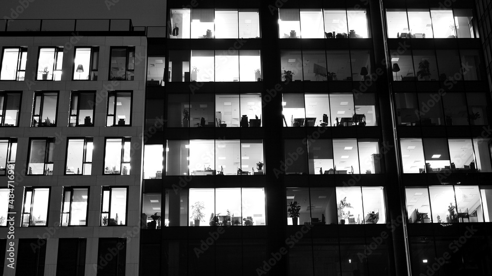 Amazing night cityscape. Office building at night, building facade with glass and lights. View with illuminated modern skyscraper. Scenic glowing windows of skyscrapers at evening. Black and white. Amazing night cityscape. Office building at night, building facade with glass and lights. View with illuminated modern skyscraper. Scenic glowing windows of skyscrapers at evening. Black and white.