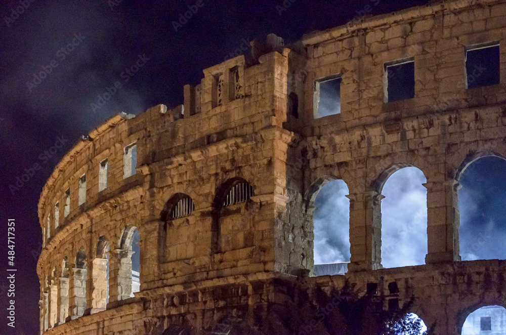 The Pula Arena Roman Amphitheatre in Croatia at Night Hosting a Live Concert. Smoke is Coming out the Arched Walls.  Famous Tourist Destination.