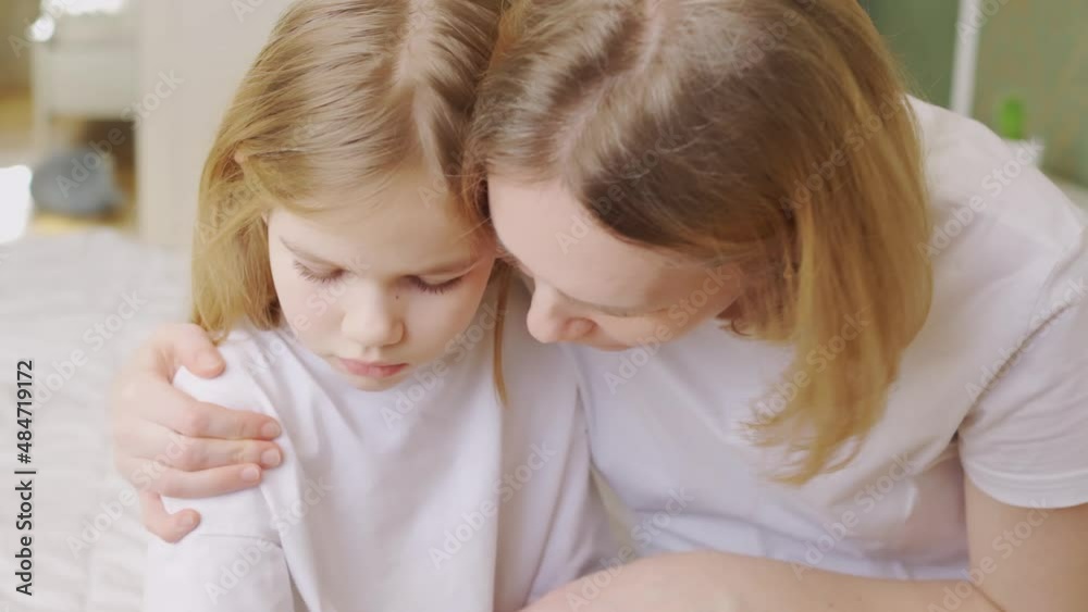 mom hugs and comforts her upset little daughter at home. mom hugs and comforts her upset little daughter at home.