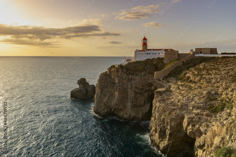 Lighthouse standing on the edge of the cliff at Cabo de Sao Vicente in Portugal's Algarve region at sunset