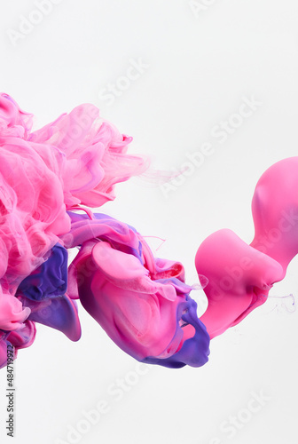Beautiful pink paint splash curves in water on white. Acrylic paint drop background. Abstract colors swirl texture