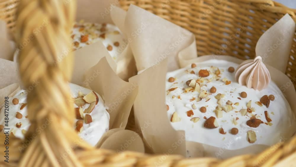 Close-up. Paska, Easter cake with white glaze and decor, sprinkling. Russian and Ukrainian Easter cake for Eastern Europe. Delicious handmade Orthodox Easter bread in a basket. On a gray background.