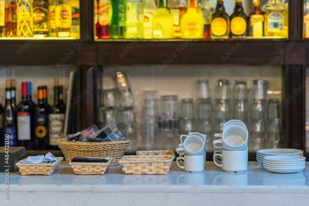 Tidy arrangement of cups and beverage at bar counter Tidy arrangement of cups and beverage at bar counter