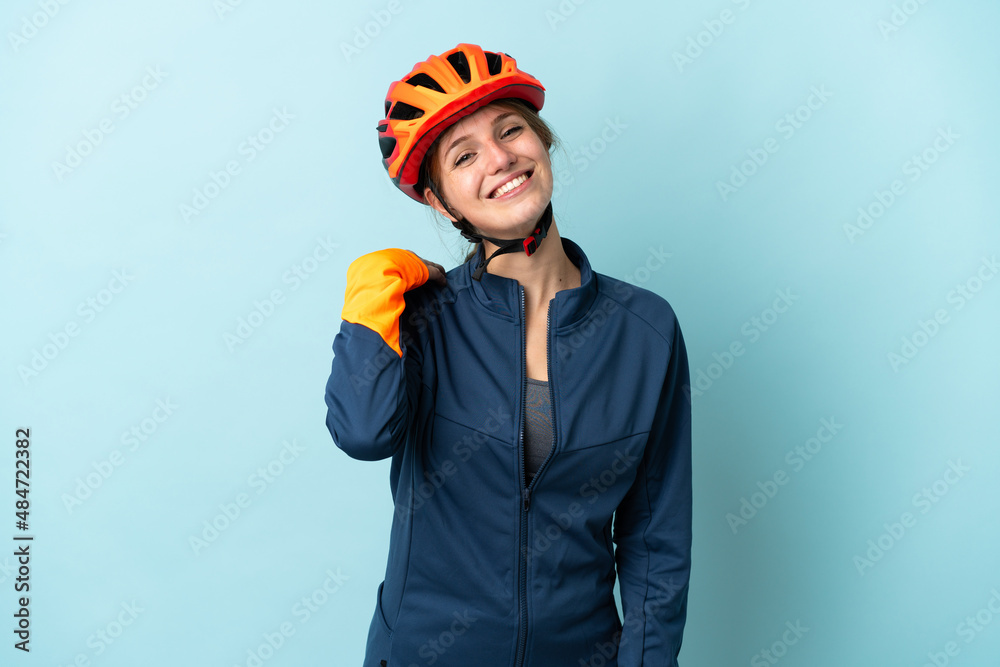 Young cyclist woman isolated on blue background laughing - obrazy, fototapety, plakaty 