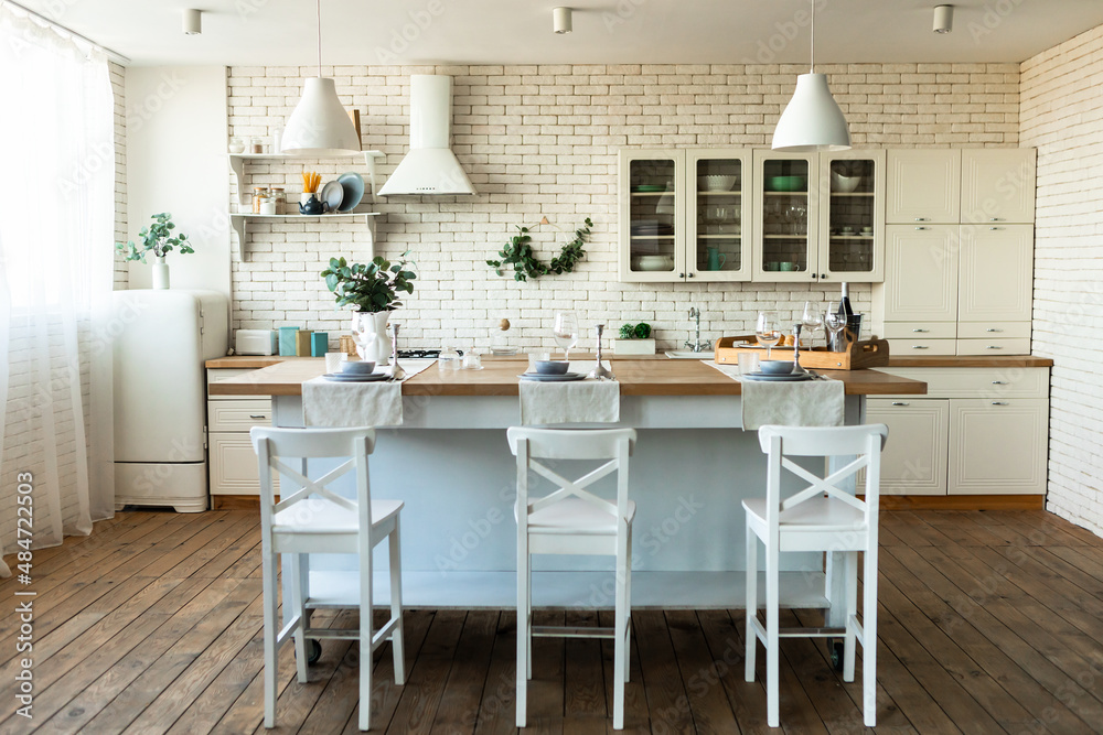 Light sunny kitchen or dining room in Scandinavian style. Modern interior with white kitchen furniture. Home decor