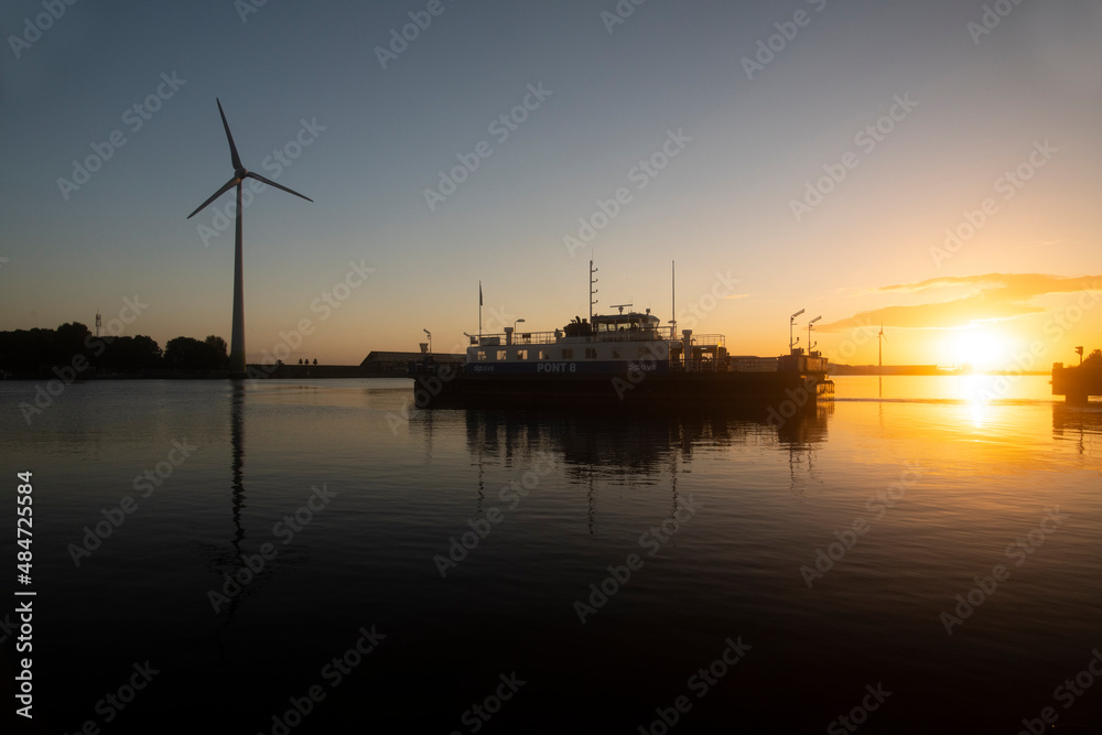 Ferry crossing a river during dawn sunrise Ferry crossing a river during dawn sunrise