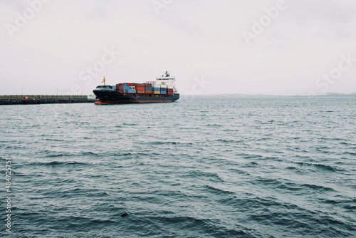Cargo ship on ocean with dock in port