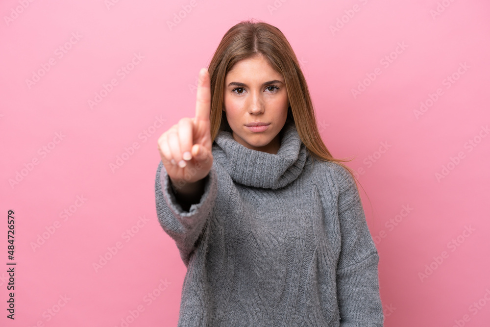 Young caucasian woman isolated on pink bakcground counting one with serious expression Young caucasian woman isolated on pink bakcground counting one with serious expression